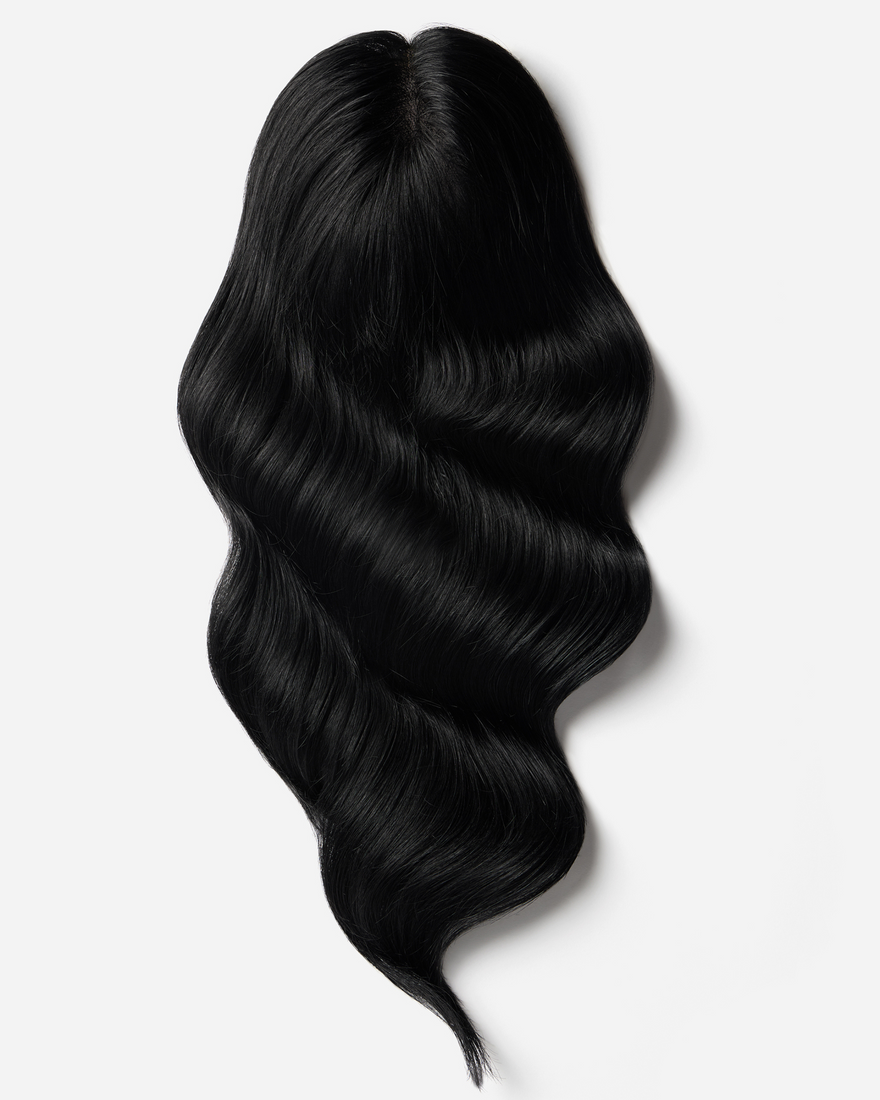 A sleek black wig displayed on a white background showcases Toppers Hair extensions' elegant design.