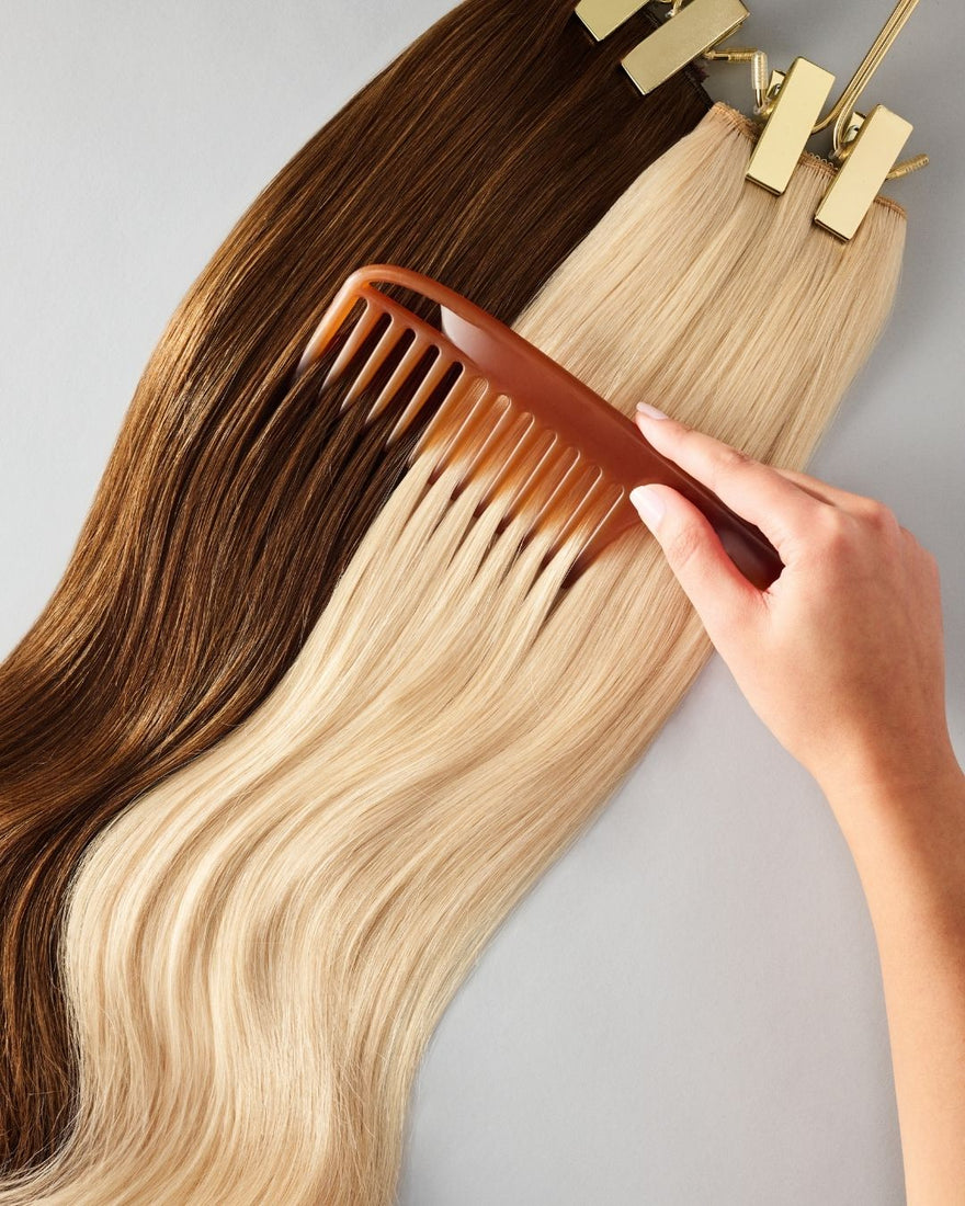 A woman carefully combs her hair extensions with a comb, ensuring smooth and tangle-free locks.
