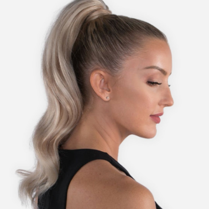 A woman in a black t-shirt showcases a ponytail styled with a side part, enhanced with hair extensions.